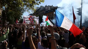 A protester holds a French national flag with the slogan "Peace on you" during a demonstration in Paris as part of a day of nationwide strikes and protests against the government and cuts in the next budget, with supporters of the "Bloquons Tout" (Let's Block Everything) movement, France, September 18, 2025. REUTERS/Tom Nicholson/Tom Nicholson