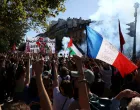 A protester holds a French national flag with the slogan "Peace on you" during a demonstration in Paris as part of a day of nationwide strikes and protests against the government and cuts in the next budget, with supporters of the "Bloquons Tout" (Let's Block Everything) movement, France, September 18, 2025. REUTERS/Tom Nicholson/Tom Nicholson