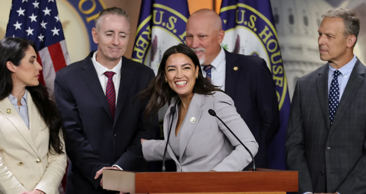 U.S. Representative Alexandria Ocasio-Cortez (D-NY), with Rep. Brian Fitzpatrick (R-PA), Rep. Anna Paulina Luna (R-FL), Rep. Chip Roy (R-TX) and Rep. Scott Perry (R-PA) smiles at a news conference with a bipartisan group of House members to say they are prepared to force a vote on legislation to ban members of Congress and their families from trading stocks on Capitol Hill in Washington, D.C., U.S., September 3, 2025. REUTERS/Jonathan Ernst/Jonathan Ernst