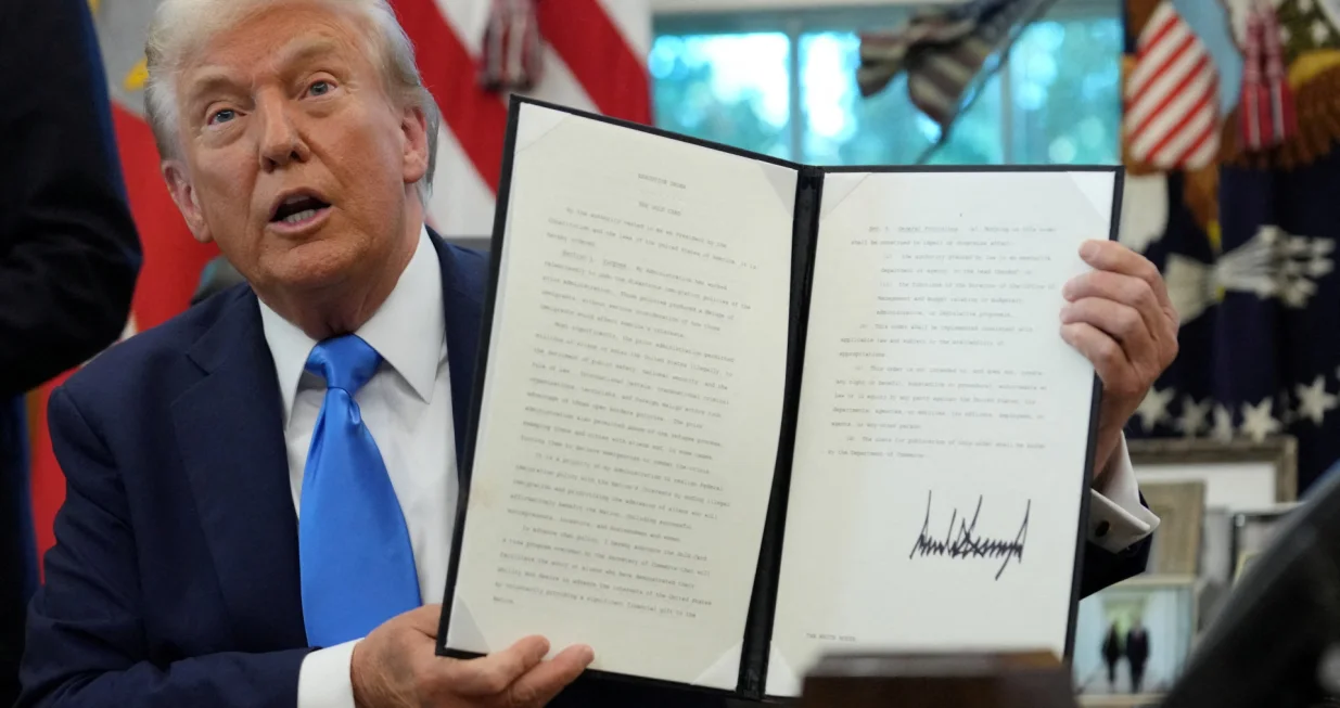U.S. President Donald Trump displays a signed executive order on gold card visa in the Oval Office at the White House in Washington, D.C., U.S., September 19, 2025. REUTERS/Ken Cedeno  TPX IMAGES OF THE DAY/Ken Cedeno