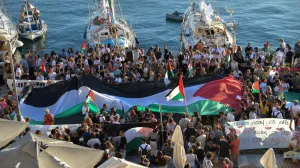 A Palestinian flag is seen as people gather at the port of Ermoupolis before the departure of two sailing boats, Electra and Oxygen, part of the Global Sumud Flotilla aiming to reach Gaza and break Israel's naval blockade, on Syros island, Greece, September 14, 2025. REUTERS/Giorgos Solaris/Giorgos Solaris
