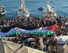 A Palestinian flag is seen as people gather at the port of Ermoupolis before the departure of two sailing boats, Electra and Oxygen, part of the Global Sumud Flotilla aiming to reach Gaza and break Israel's naval blockade, on Syros island, Greece, September 14, 2025. REUTERS/Giorgos Solaris/Giorgos Solaris