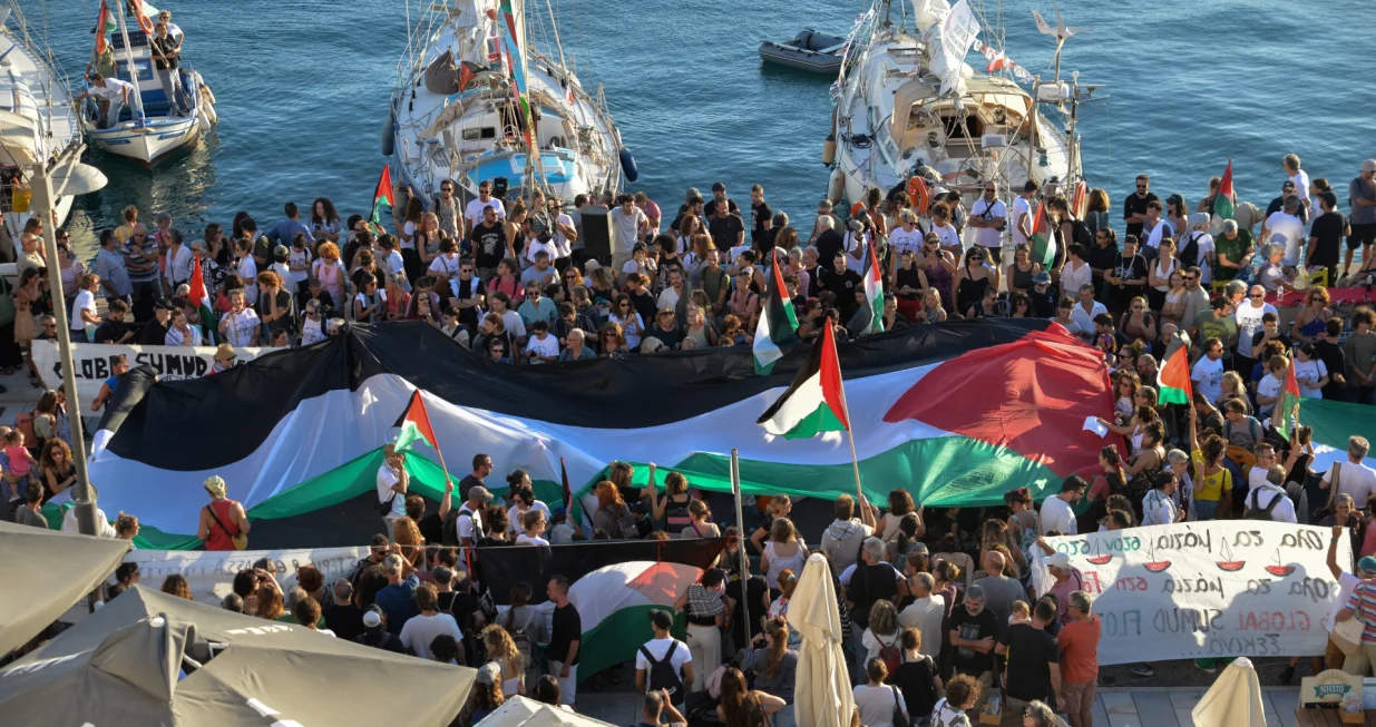 A Palestinian flag is seen as people gather at the port of Ermoupolis before the departure of two sailing boats, Electra and Oxygen, part of the Global Sumud Flotilla aiming to reach Gaza and break Israel's naval blockade, on Syros island, Greece, September 14, 2025. REUTERS/Giorgos Solaris/Giorgos Solaris
