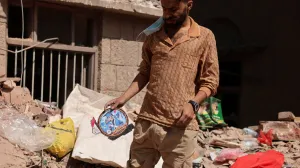 A man holds a picture of a boy as he stand at the site of a house destroyed in Wednesday's Israeli airstrikes in Sanaa, Yemen September 13, 2025. REUTERS/Khaled Abdullah/Khaled Abdullah