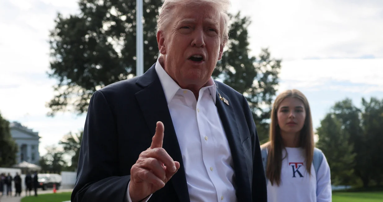 U.S. President Donald Trump speaks to the media as his granddaughter Kai Madison Trump looks on before departing for travel to New York to attend the Ryder Cup golf tournament, from the White House in Washington, D.C., U.S., September 26, 2025 REUTERS/Jonathan Ernst/Jonathan Ernst