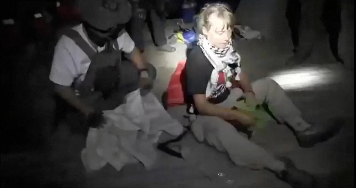 A screengrab from a video shows Swedish activist Greta Thunberg sitting next to a person wearing tactical gear, as vessels of the Global Sumud Flotilla are being intercepted by Israeli security forces, October 1, 2025. Israel Foreign Ministry/Handout via REUTERS THIS IMAGE HAS BEEN SUPPLIED BY A THIRD PARTY. MANDATORY CREDIT. NO RESALES. NO ARCHIVES./Israel Foreign Ministry