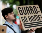 A protestor holds a sign at a rally at Mark O. Hatfield Federal Courthouse, as protestors anticipate a ruling by Federal District Court Judge Karin Immergut regarding President Donald Trump's plan to deploy National Guard members in Portland, in Portland, Oregon, U.S., October 3, 2025. REUTERS/John Rudoff/John Rudoff