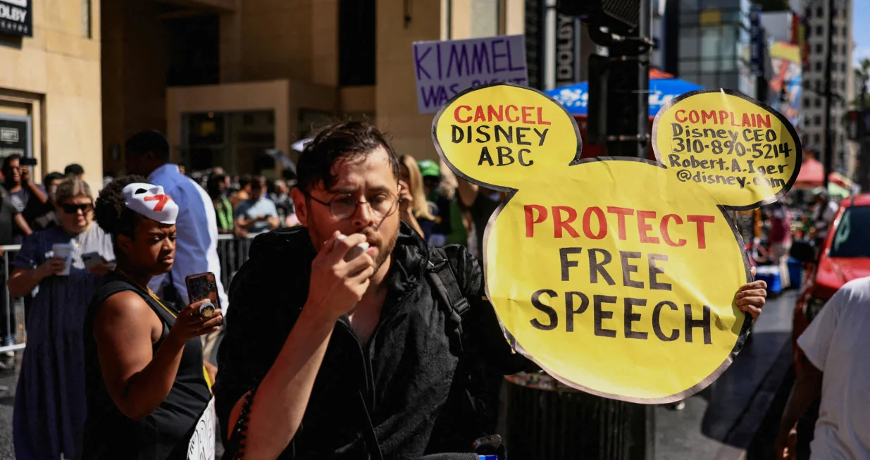 FILE PHOTO: A man holds a sign in the shape of Mickey Mouse's face during a protest outside the Dolby Theatre, across the street from the theater where "Jimmy Kimmel Live!" was recorded for broadcast, following his suspension for remarks he made regarding Charlie Kirk's assassination, on Hollywood Boulevard in Los Angeles, California, U.S. September 22, 2025. REUTERS/David Swanson/File Photo/David Swanson