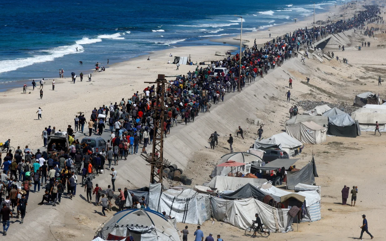 Palestinians, who were displaced to the southern part of Gaza at Israel's order during the war, walk along a road as they attempt to return to the north after a ceasefire between Israel and Hamas in Gaza went into effect, in the central Gaza Strip, October 10, 2025. REUTERS/Mahmoud Issa  TPX IMAGES OF THE DAY/Mahmoud Issa