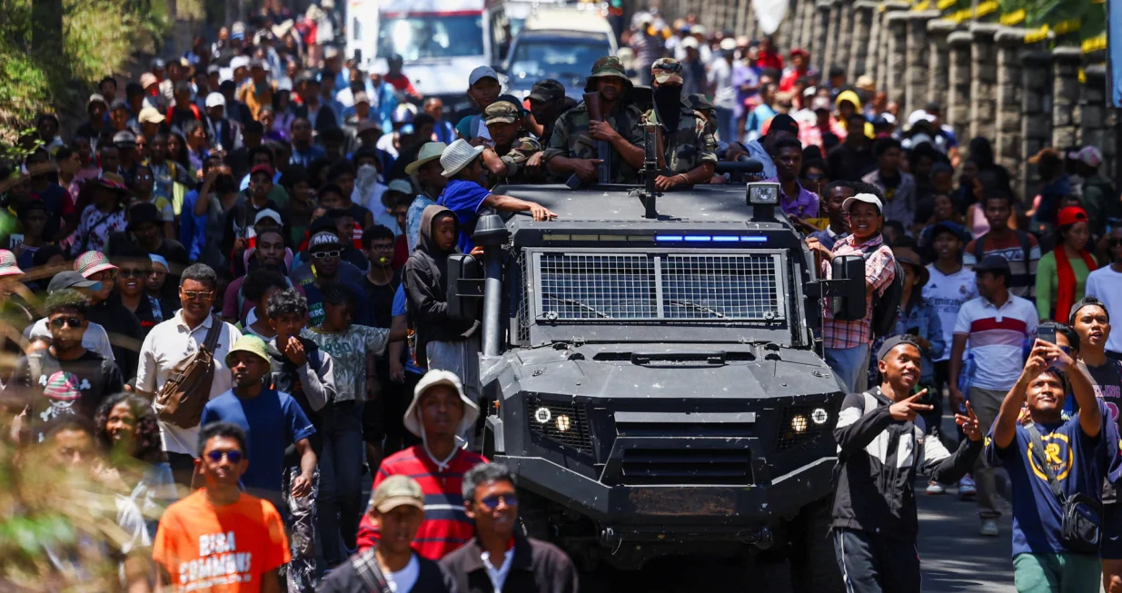 Protesters march alongside a Madagascar military vehicle during a nationwide youth-led protest over frequent power outages and water shortages, in Antananarivo, Madagascar, October 13, 2025. REUTERS/Siphiwe Sibeko/Siphiwe Sibeko