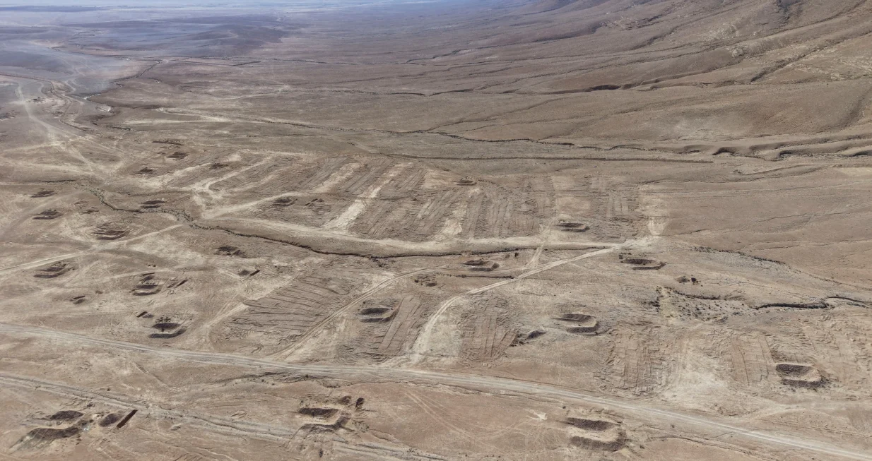 A drone view of the mass grave site in the desert near the eastern Syrian town of Dhumair, February 27, 2025. A Reuters investigation found that the Assad government secretly trucked thousands of bodies there from an exposed mass grave in the Damascus suburb of Qutayfah from 2019-2021. REUTERS/Khalil Ashawi/Khalil Ashawi