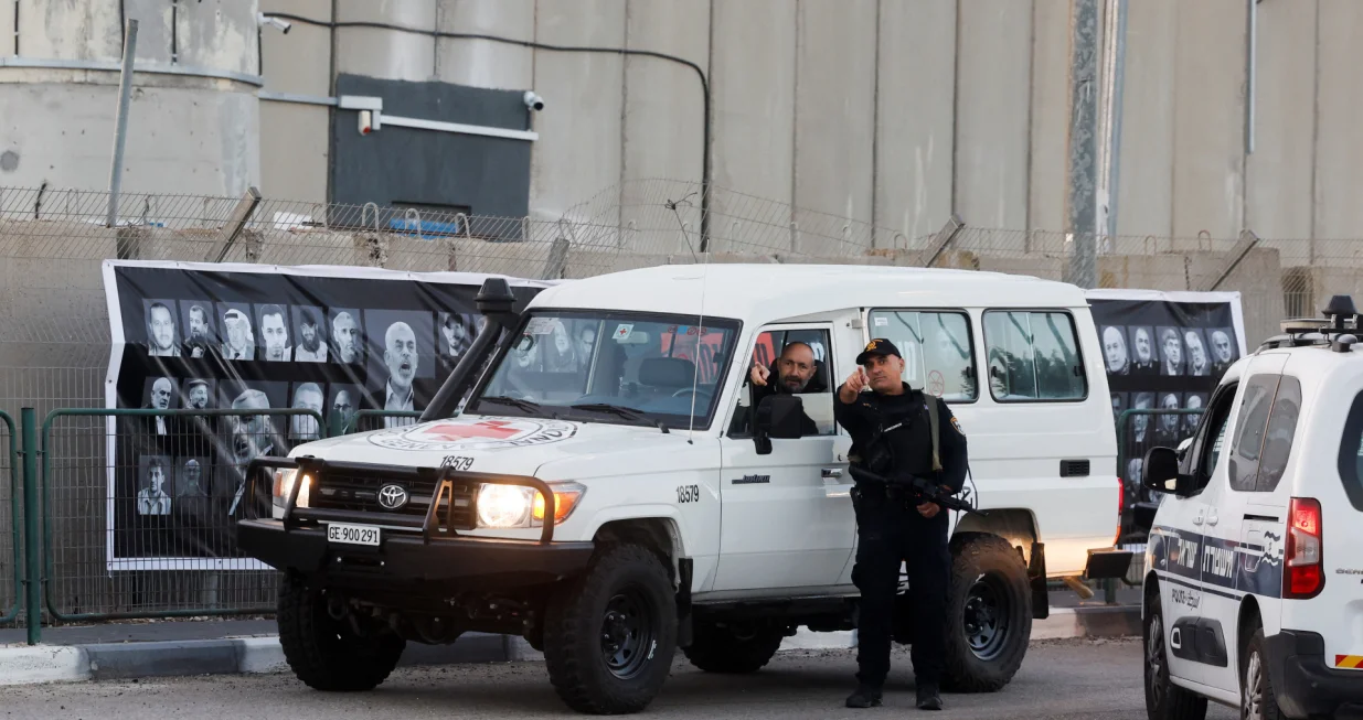 A security official stands next to a vehicle outside the Israeli military prison, Ofer, on the day Israel is expected to release Palestinian prisoners as part of a hostages-prisoners swap and a ceasefire deal in Gaza between Hamas and Israel, near Ramallah, in the Israeli-occupied West Bank, October 13, 2025. REUTERS/Ammar Awad/Ammar Awad