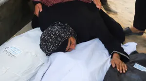 A relative embraces body bags, during the funeral for members of the Abu Amsha family, who were killed in an Israeli strike on a house on Saturday amid their military operation, according to medics, at Al-Shifa Hospital in Gaza City, September 21, 2025. REUTERS/Ebrahim Hajjaj/Ebrahim Hajjaj