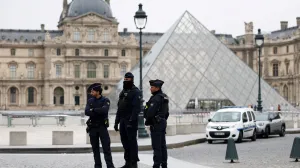 Police officers stand near the pyramid of the Louvre museum after reports of a robbery, in Paris, France, October 19, 2025. REUTERS/Gonzalo Fuentes  TPX IMAGES OF THE DAY/Gonzalo Fuentes