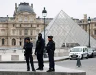 Police officers stand near the pyramid of the Louvre museum after reports of a robbery, in Paris, France, October 19, 2025. REUTERS/Gonzalo Fuentes  TPX IMAGES OF THE DAY/Gonzalo Fuentes