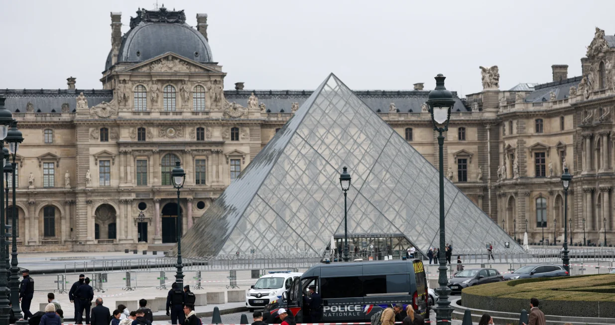 Police stand near the pyramid of the Louvre museum after reports of a robbery, in Paris, France, October 19, 2025. REUTERS/Gonzalo Fuentes/Gonzalo Fuentes