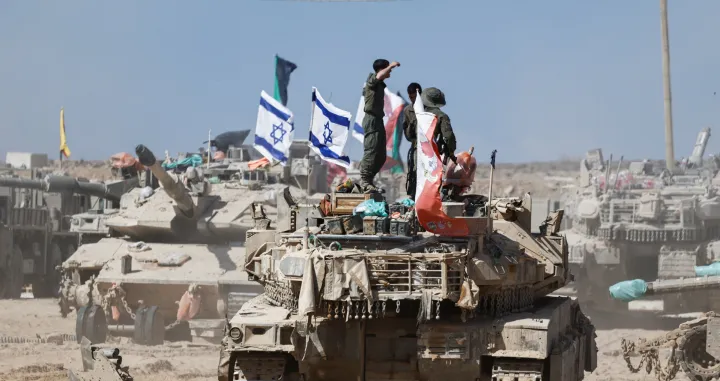 Israeli soldiers stand on a tank near the Israel-Gaza border, in Israel, October 19, 2025. REUTERS/Amir Cohen/Amir Cohen