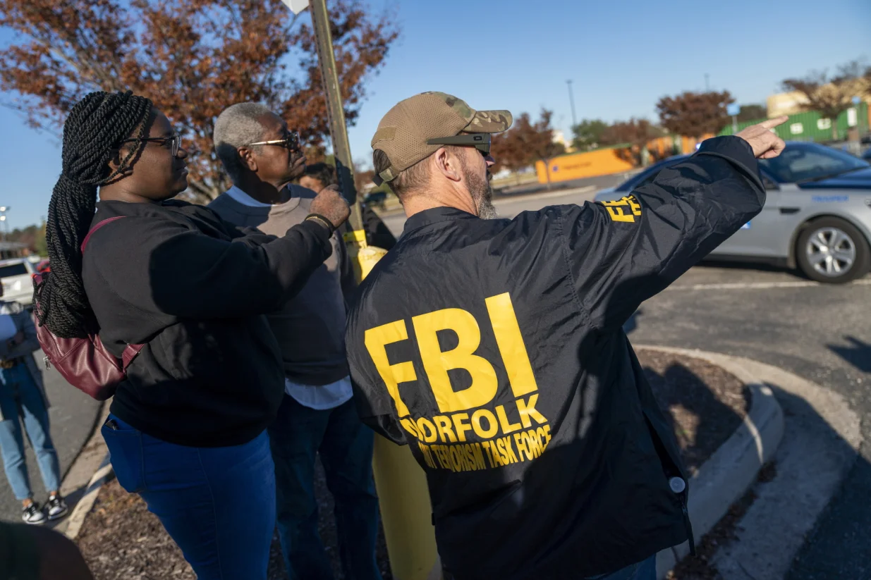 epa10323770 An FBI agent works to help people recover their cars from the the scene of a mass shooting at the Walmart Supercenter in Chesapeake, Virginia, USA, 23 November 2022. The shooting at around 10:15 pm on 22 November left at least seven people including the shooter dead, police said. EPA/SHAWN THEW/Shawn Thew