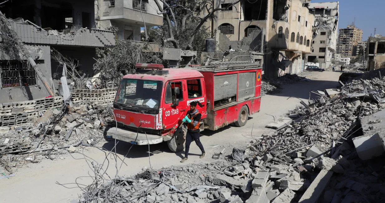 A member of the civil defense walks next to a fire truck as the team searches for bodies trapped under the rubble of destroyed buildings, amid a severe lack of equipment and capabilities needed to recover the victims, according to Palestinian Civil Defense, in Gaza City, October 20, 2025. REUTERS/Ebrahim Hajjaj/Ebrahim Hajjaj
