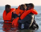 Migrants wade through the sea in an attempt to board an inflatable dinghy, leaving the beach of Petit-Fort-Philippe in northern France to cross the English Channel to reach Britain, in Gravelines, near Calais, France, September 27, 2025. REUTERS/Abdul Saboor/Abdul Saboor