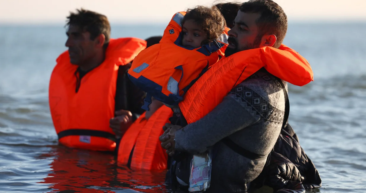 Migrants wade through the sea in an attempt to board an inflatable dinghy, leaving the beach of Petit-Fort-Philippe in northern France to cross the English Channel to reach Britain, in Gravelines, near Calais, France, September 27, 2025. REUTERS/Abdul Saboor/Abdul Saboor