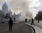 Police officers secure the area as smoke rises from a burning tent following an incident in front of the Parliament in Belgrade, Serbia, October 22, 2025. REUTERS/Djordje Kojadinovic/Djordje Kojadinovic