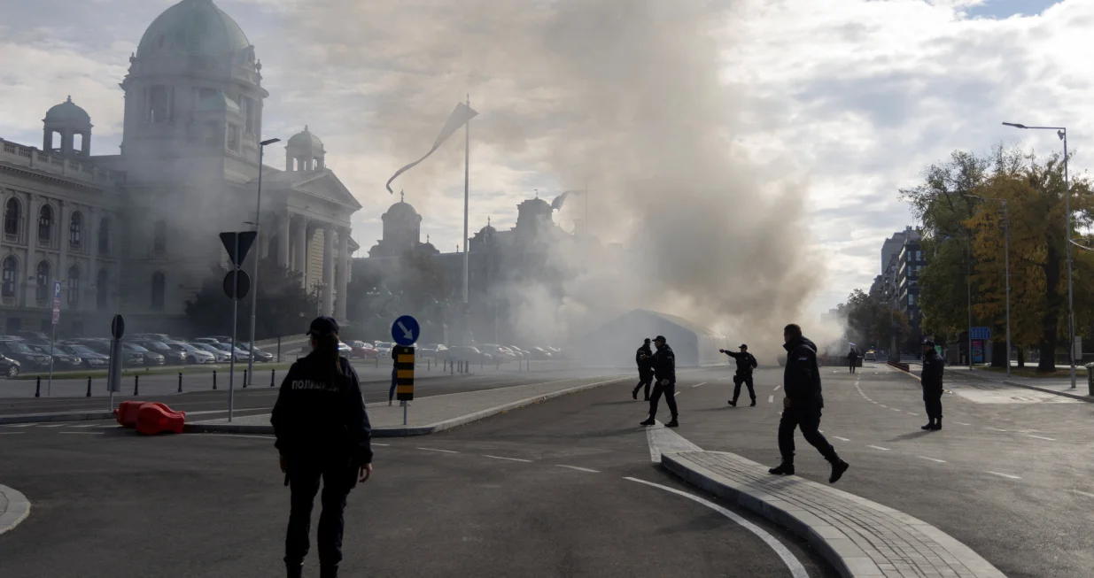 Police officers secure the area as smoke rises from a burning tent following an incident in front of the Parliament in Belgrade, Serbia, October 22, 2025. REUTERS/Djordje Kojadinovic/Djordje Kojadinovic