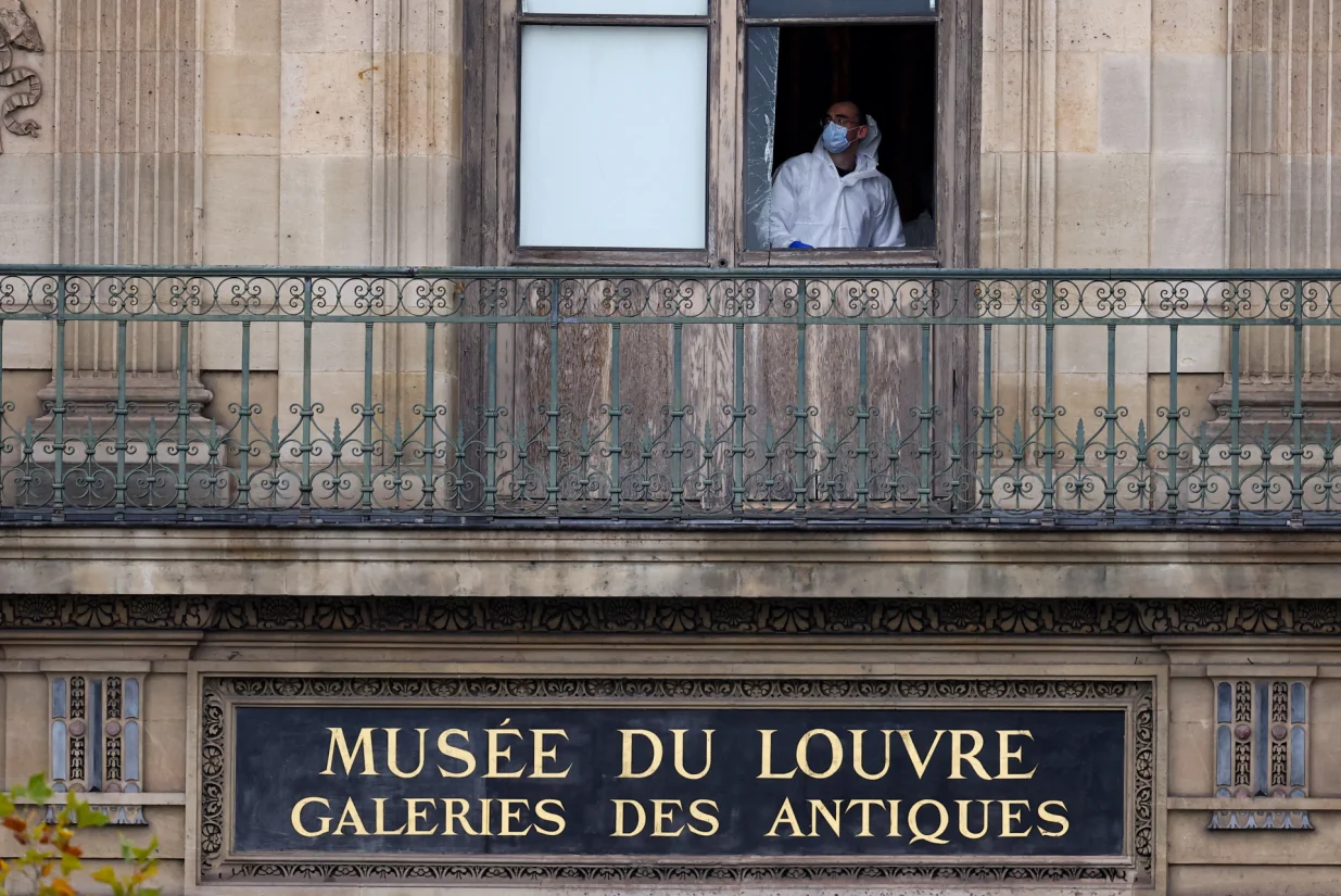 A member of a forensic team inspects a window believed to have been used in what the French Interior Ministry said was a robbery at the Louvre museum during which jewellery was stolen, in Paris, France, October 19, 2025. REUTERS/Gonzalo Fuentes/Gonzalo Fuentes