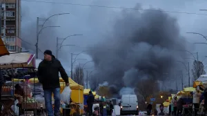 Residents buy groceries at a street market as smoke rises at the site of food warehouses hit by an overnight Russian missile strike, amid Russia's attack on Ukraine, in Kyiv, Ukraine October 25, 2025. REUTERS/Yan Dobronosov/Yan Dobronosov