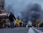 Residents buy groceries at a street market as smoke rises at the site of food warehouses hit by an overnight Russian missile strike, amid Russia's attack on Ukraine, in Kyiv, Ukraine October 25, 2025. REUTERS/Yan Dobronosov/Yan Dobronosov