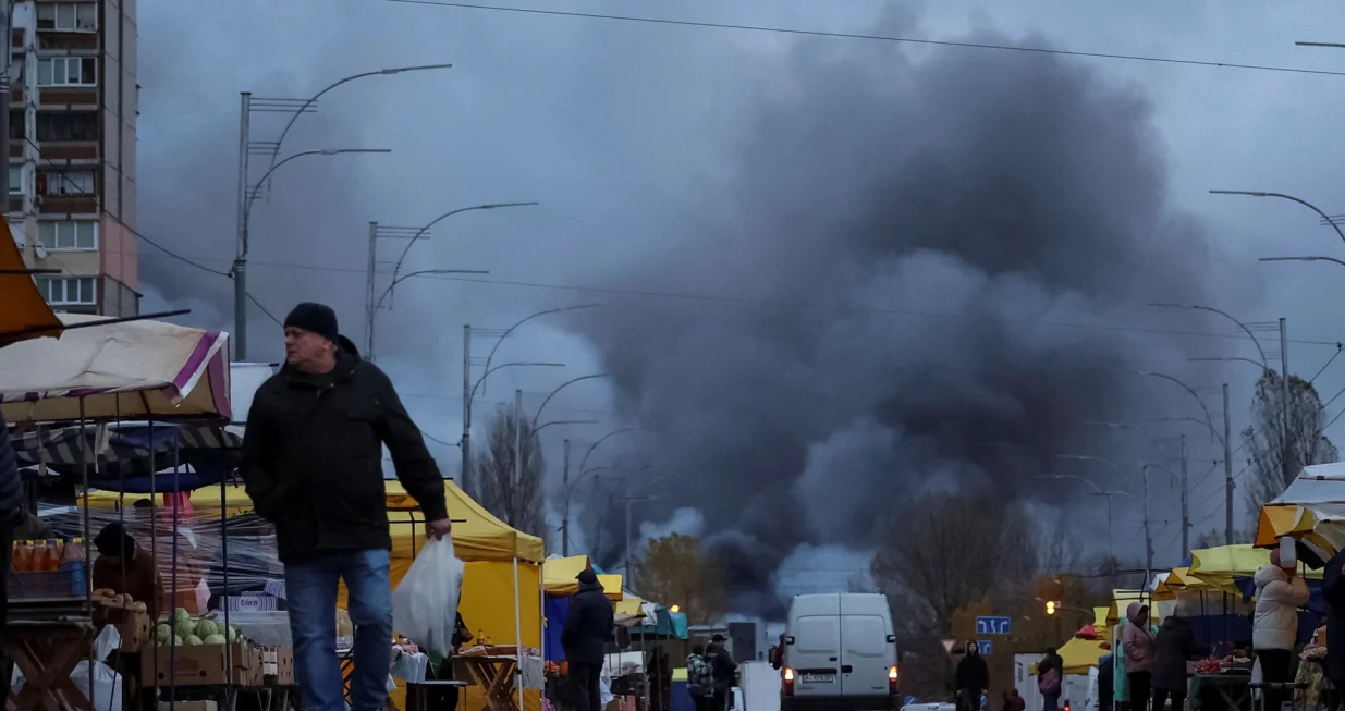 Residents buy groceries at a street market as smoke rises at the site of food warehouses hit by an overnight Russian missile strike, amid Russia's attack on Ukraine, in Kyiv, Ukraine October 25, 2025. REUTERS/Yan Dobronosov/Yan Dobronosov