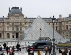 Police stand near the pyramid of the Louvre museum after reports of a robbery, in Paris, France, October 19, 2025. REUTERS/Gonzalo Fuentes/Gonzalo Fuentes