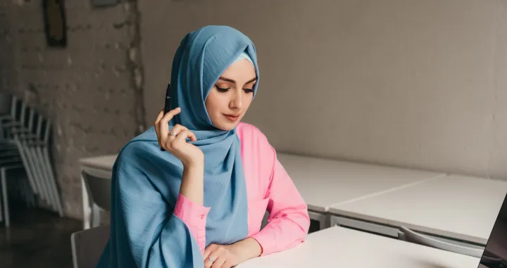 young pretty modern muslim woman in hijab working on laptop in office room, education online, remote work freelancer, making notes thinking, hidžab, posao, žena/Freepik