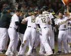 epa09349757 Oakland Athletics Jed Lowrie (2-R) is mobbed by his teammates after hitting a game winning walk-off two run home run off Cleveland Indians relief pitcher Emmanuel Clase during the ninth inning of the Major League Baseball (MLB) game between the Cleveland Indians and the Oakland Athletics at RingCentral Coliseum in Oakland, California, USA, 16 July 2021. EPA/JOHN G. MABANGLO/Foto: John G. Mabanglo