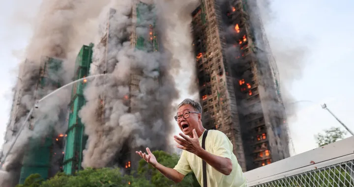 Wong 71, reacts after claiming his wife is trapped inside Wang Fuk Court during a major fire, in Tai Po, Hong Kong, China, November 26, 2025. REUTERS/Tyrone Siu TPX IMAGES OF THE DAY/Tyrone Siu