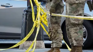 National Guard members stand together behind yellow tape, after two National Guard members were shot near the White House in Washington, D.C., U.S., November 26, 2025. REUTERS/Nathan Howard/Nathan Howard