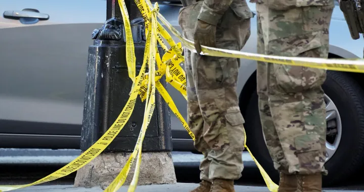 National Guard members stand together behind yellow tape, after two National Guard members were shot near the White House in Washington, D.C., U.S., November 26, 2025. REUTERS/Nathan Howard/Nathan Howard