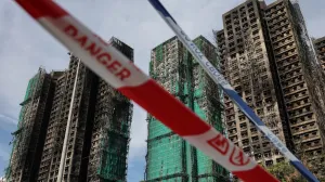 Police cordons are placed at the scene of the Wang Fuk Court housing estate fire as mourners pay tribute to the victims, in Tai Po, Hong Kong, China, November 28, 2025. REUTERS/Tyrone Siu/Tyrone Siu