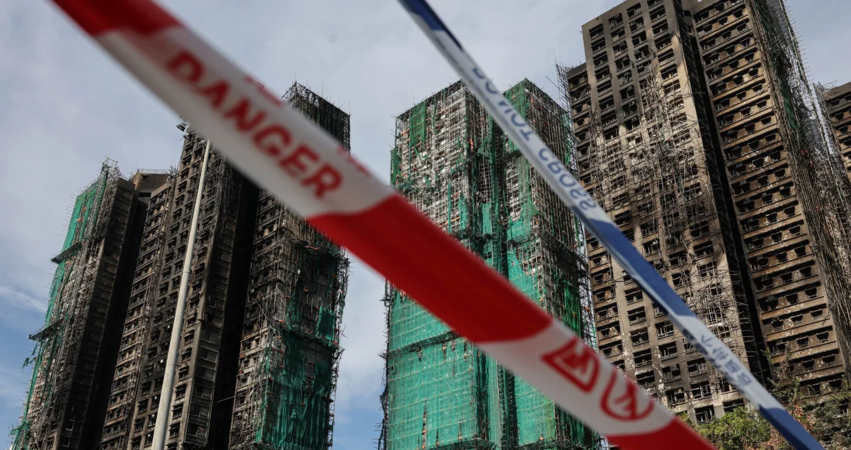 Police cordons are placed at the scene of the Wang Fuk Court housing estate fire as mourners pay tribute to the victims, in Tai Po, Hong Kong, China, November 28, 2025. REUTERS/Tyrone Siu/Tyrone Siu