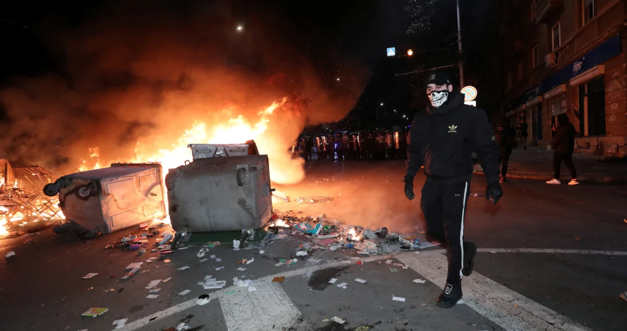 A protester walks past overturned garbage bins, following scuffles with police during a demonstration organised by Bulgaria's opposition PP-DB coalition against the proposed financial framework of the country's budget, Sofia, Bulgaria, December 1, 2025. REUTERS/Dimitar Kyosemarliev/Dimitar Kyosemarliev