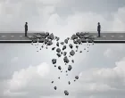 Business deal failure concept as two businessmen on a road bridge that is breaking down and disconnecting as a failing corporate relationship crisis symbol./