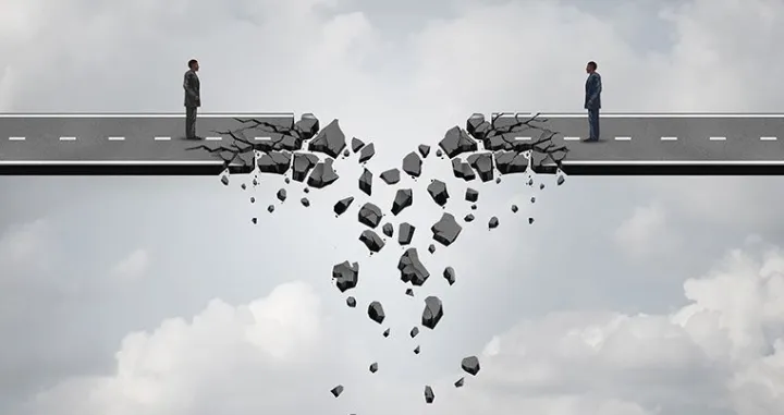 Business deal failure concept as two businessmen on a road bridge that is breaking down and disconnecting as a failing corporate relationship crisis symbol./
