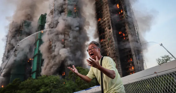 Wong, 71, reacts after saying his wife is trapped inside Wang Fuk Court during a major fire, in Tai Po, Hong Kong, China, November 26, 2025. REUTERS/Tyrone Siu   SEARCH "HONG KONG FIRE PICTURE" FOR THIS STORY. SEARCH "WIDER IMAGE" FOR ALL STORIES.  TPX IMAGES OF THE DAY/Tyrone Siu