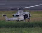 A U.S. military service member hangs from a U.S. Marine Corps UH-1Y Venom helicopter as it hovers over a taxiway during a training exercise at the former Roosevelt Roads naval base in Ceiba, Puerto Rico, December 22, 2025. REUTERS/Ricardo Arduengo/Ricardo Arduengo
