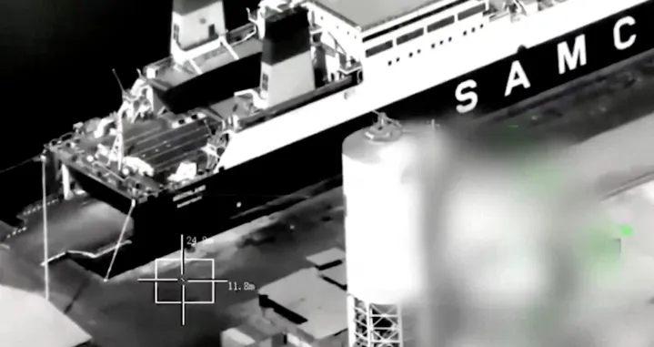 A screenshot from footage released by the Saudi-led Coalition shows what is says is the arrival of the "Greeland" ship from Al Fujairah port to Al Mukalla Port, carrying what it described as foreign military support to UAE-backed southern separatists, in Yemen's southern port of Mukalla, in this screengrab from a handout video obtained by Reuters on December 30, 2025. Saudi-led Coalition/Handout via REUTERS THIS IMAGE HAS BEEN SUPPLIED BY A THIRD PARTY. TEXT OVERLAY AND BLURRING FROM SOURCE. VERIFICATION LINES: Storage tanks, vehicles and the wall match with satellite images and corroborating footages showing the fire. Date not verified by Reuters./Saudi-led Coalition