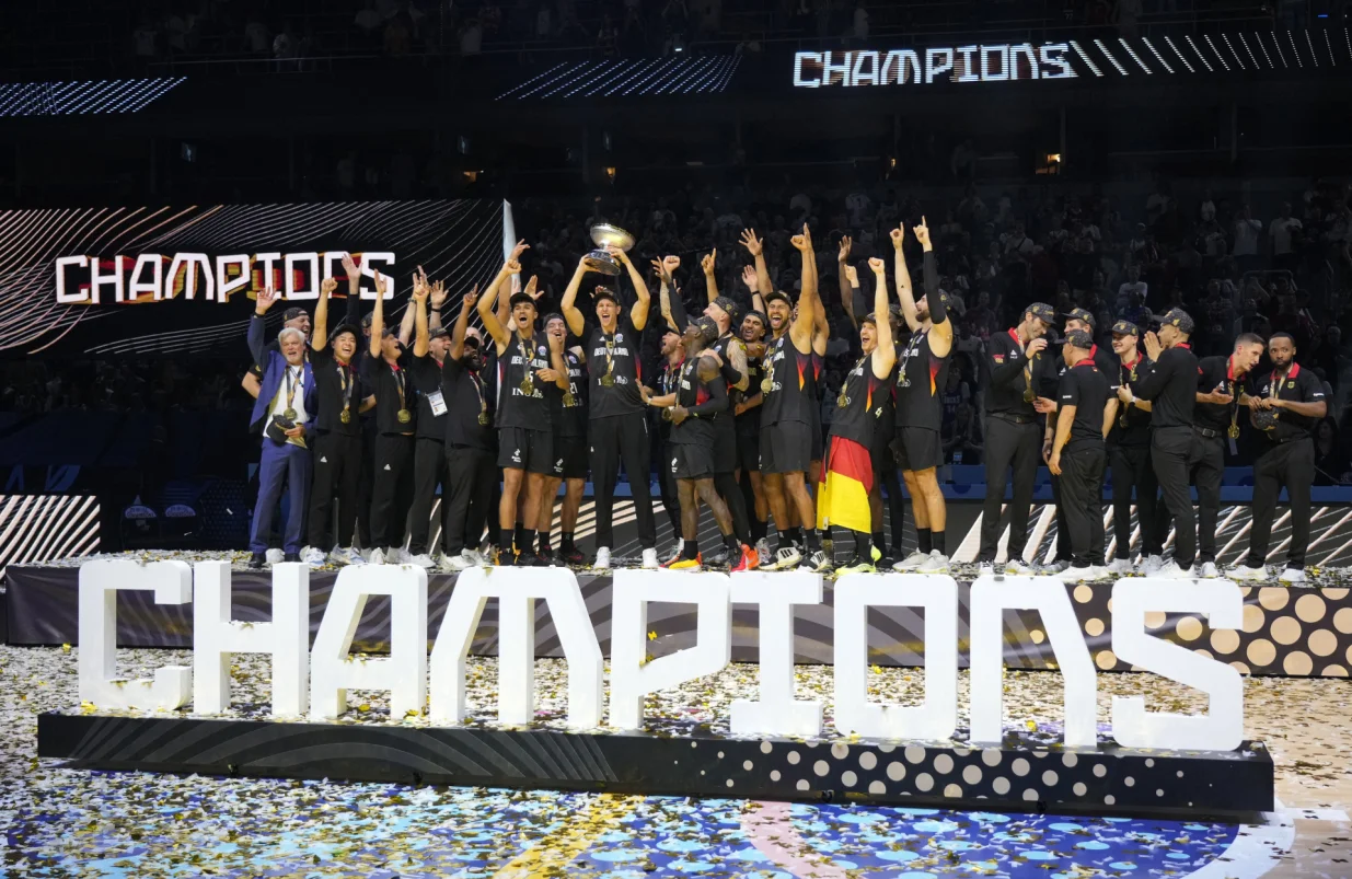 Basketball - FIBA EuroBasket 2025 - Final - Turkey v Germany - Xiaomi Arena, Riga, Latvia - September 14, 2025 Germany's Johannes Voigtmann lifts the trophy as he celebrates with his teammates after winning the FIBA EuroBasket final REUTERS/Ints Kalnins/Foto: Ints Kalnins