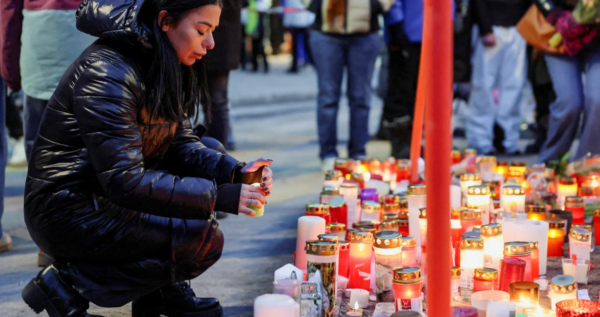 A woman places a candle outside the "Le Constellation" bar, after a fire and explosion during a New Year's Eve party where people died, and others were injured, in the upscale ski resort of Crans-Montana in southwestern Switzerland, January 2, 2026. REUTERS/Stephanie Lecocq  TPX IMAGES OF THE DAY/Stephanie Lecocq