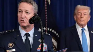 General Dan Caine, Chairman of the Joint Chiefs of Staff, speaks as U.S. President Donald Trump looks at him during a press conference following a U.S. strike on Venezuela where President Nicolas Maduro and his wife, Cilia Flores, were captured, from Trump's Mar-a-Lago club in Palm Beach, Florida, U.S., January 3, 2026. REUTERS/Jonathan Ernst  TPX IMAGES OF THE DAY/Jonathan Ernst
