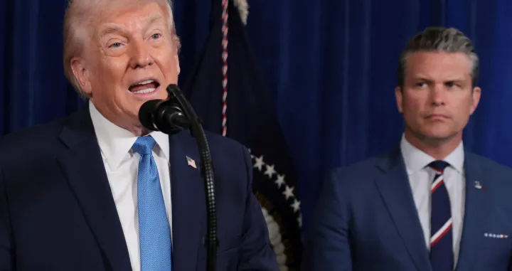 U.S. President Donald Trump speaks as Secretary of Defense Pete Hegseth looks at him during a press conference following a U.S. strike on Venezuela where President Nicolas Maduro and his wife, Cilia Flores, were captured, from Trump's Mar-a-Lago club in Palm Beach, Florida, U.S., January 3, 2026. REUTERS/Jonathan Ernst/Jonathan Ernst