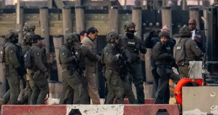 Captured Venezuelan President Nicolas Maduro is escorted, as he heads towards the Daniel Patrick Moynihan United States Courthouse in Manhattan for an initial appearance to face U.S. federal charges including narco-terrorism, conspiracy, drug trafficking, money laundering and others, at Downtown Manhattan Heliport, in New York City, U.S., January 5, 2026. REUTERS/Adam Gray/Adam Gray